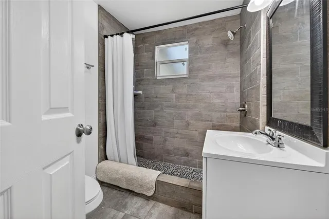 a bathroom with a sink a toilet and shower