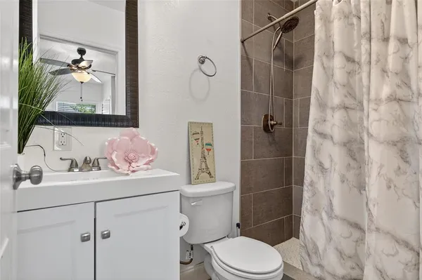 a bathroom with a sink vanity mirror and toilet