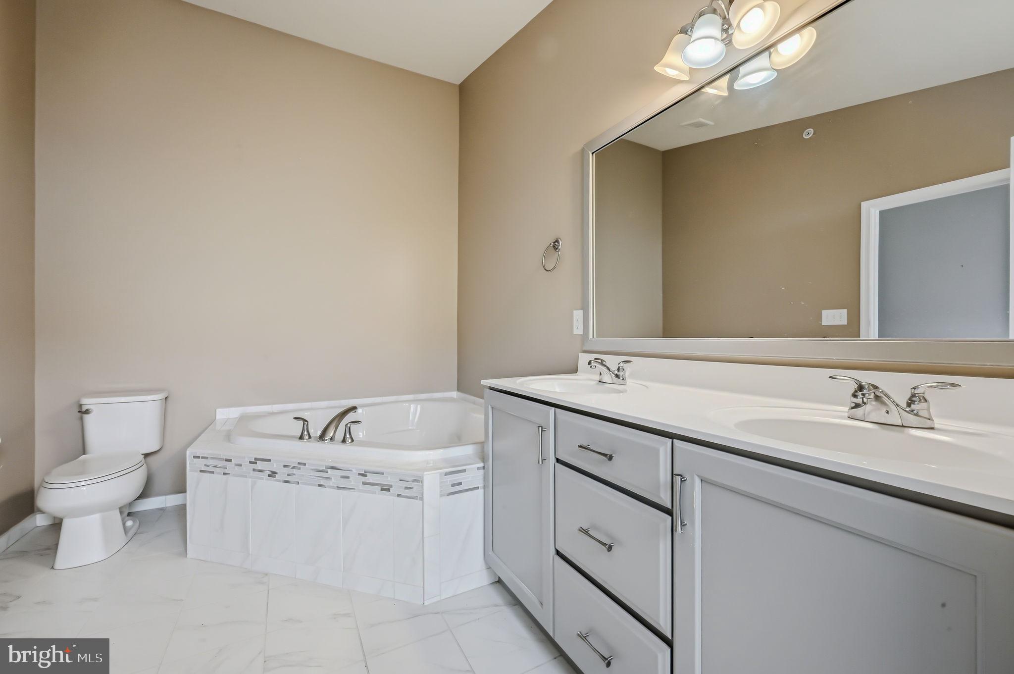208 Jackdaw Alley, Unit 208 Springfield, PA 19064 - Photo 43 of 49 a spacious bathroom with a double vanity sink and a toilet