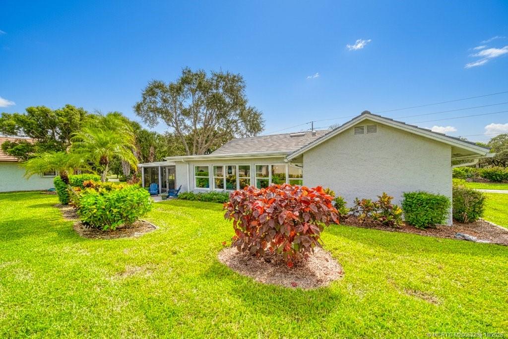 5157 Southeast Miles Grant Road Stuart, FL 34997 - Photo 20 of 32 a front view of a house with garden