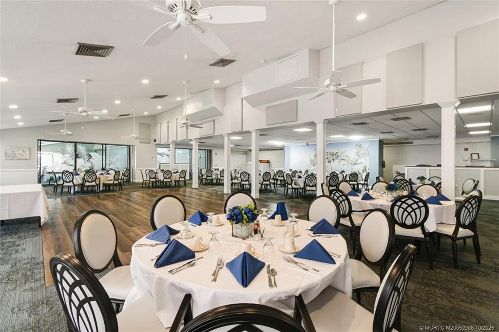 5157 Southeast Miles Grant Road Stuart, FL 34997 - Photo 25 of 32 a very nice looking dining room with furniture a kitchen and chandelier