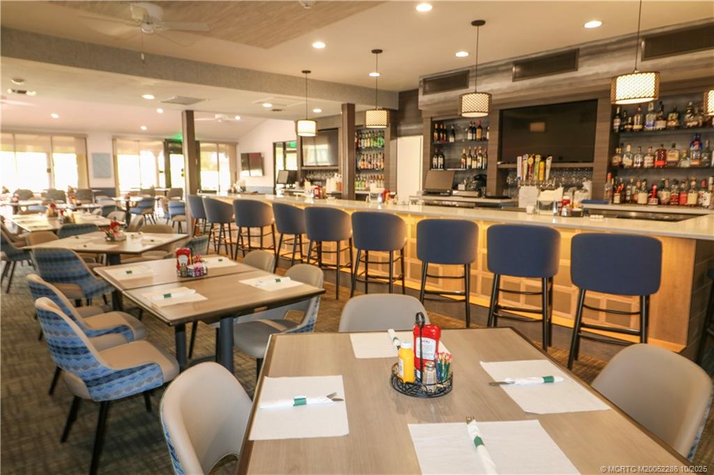 5157 Southeast Miles Grant Road Stuart, FL 34997 - Photo 28 of 32 a dining hall with stainless steel appliances kitchen island granite countertop a dining table and chairs