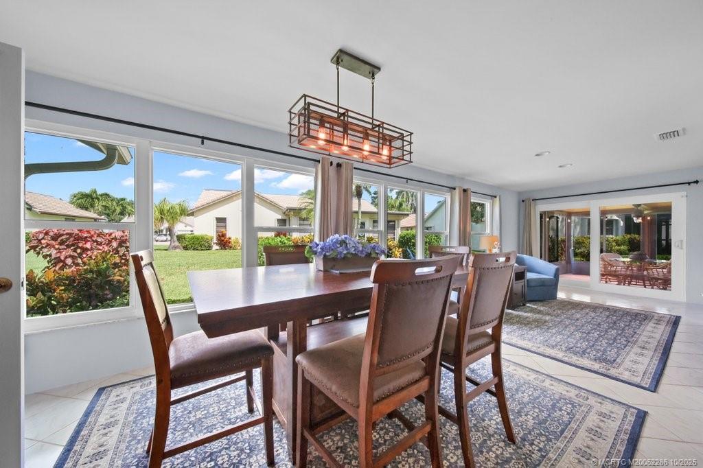 5157 Southeast Miles Grant Road Stuart, FL 34997 - Photo 8 of 32 a dining room with furniture a chandelier and wooden floor