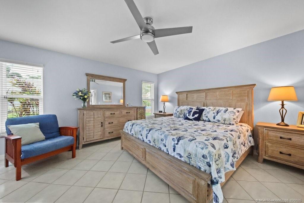 5157 Southeast Miles Grant Road Stuart, FL 34997 - Photo 10 of 32 a bedroom with a bed a couch and dresser