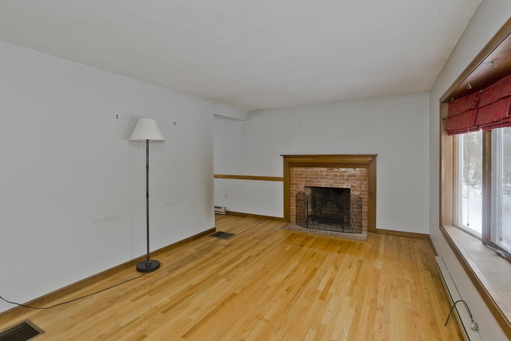 26 Falls Road Sunderland, MA 01375 - Photo 8 of 39 a view of an empty room with a fireplace and a window