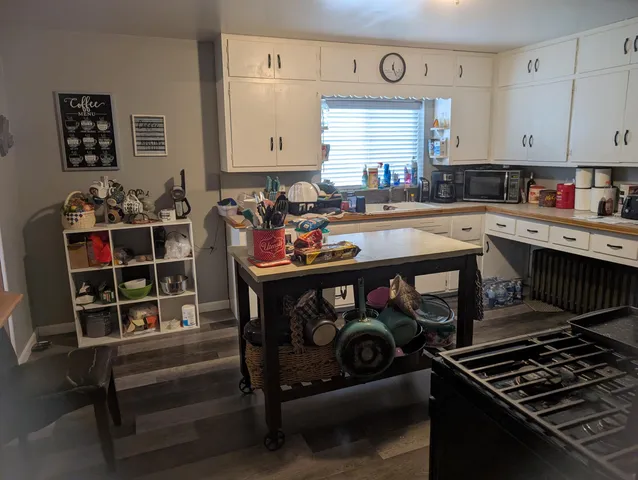 a kitchen with a sink cabinets and wooden floor