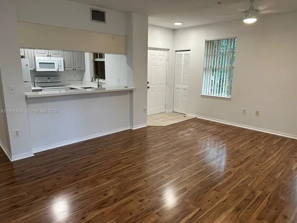 a view of kitchen with wooden floor and electronic appliances