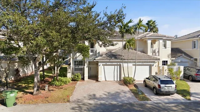 a backyard of a house with table and chairs plants and large tree