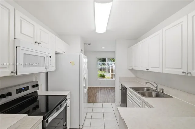 a kitchen with granite countertop a sink stainless steel appliances and cabinets
