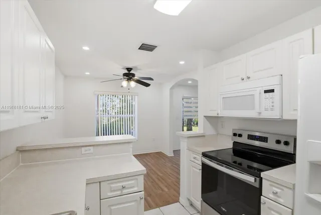 a kitchen with white cabinets and appliances