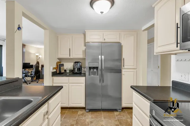 a kitchen with stainless steel appliances granite countertop a sink a refrigerator and a granite counter tops