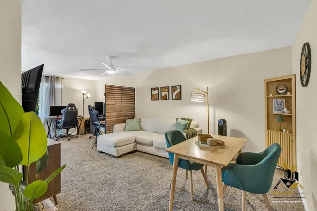 a living room with furniture a rug and a table