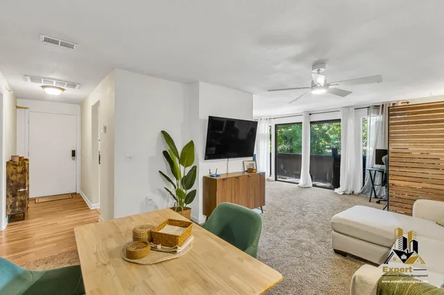 a living room with furniture a flat screen tv and a large window