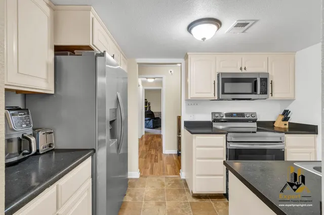 a kitchen with stainless steel appliances granite countertop a refrigerator stove and sink
