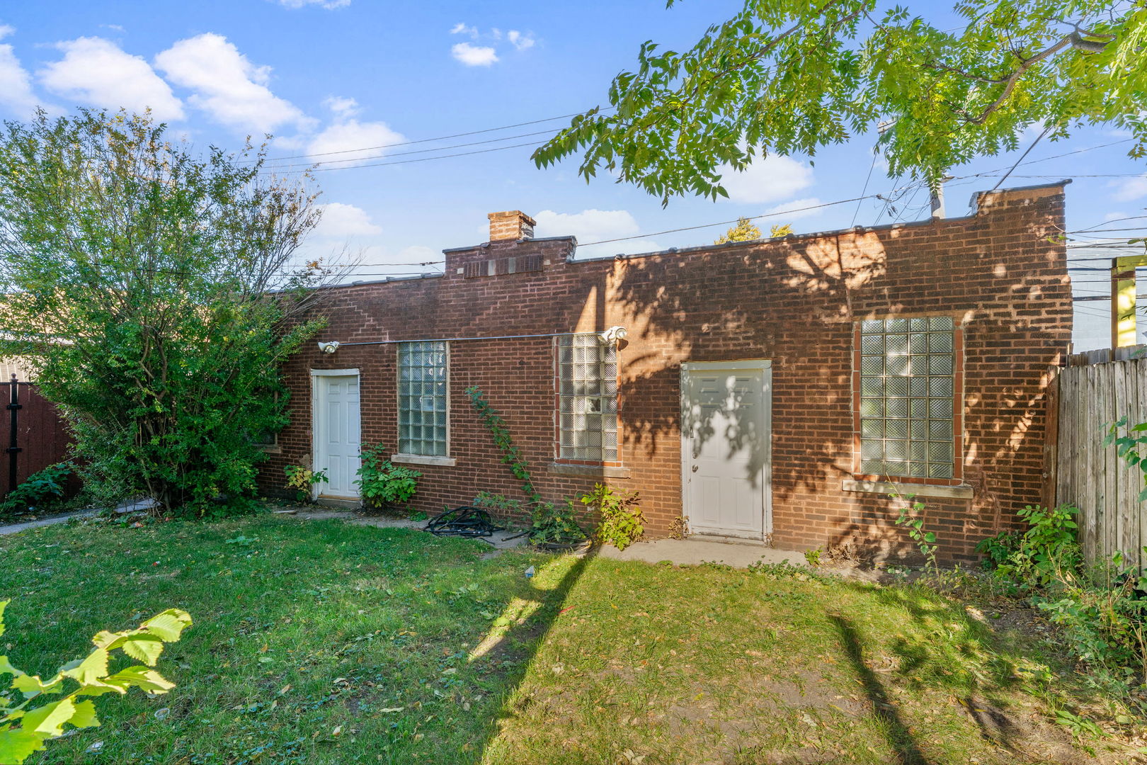 4016 West Crystal Street Chicago, IL 60651 - Photo 17 of 17 a view of a house with brick walls plants and large tree