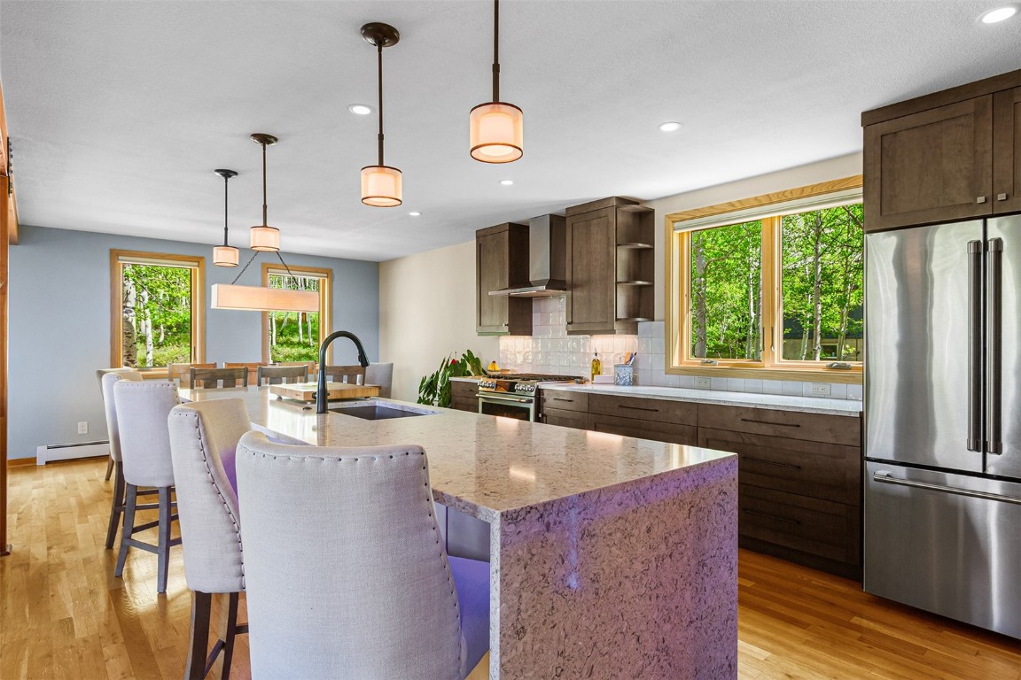 87 Spring Beauty Drive Silverthorne, CO 80498 - Photo 14 of 36 a kitchen with kitchen island a large counter top space appliances and a chandelier