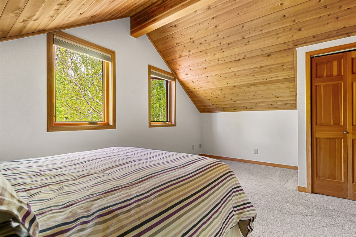 87 Spring Beauty Drive Silverthorne, CO 80498 - Photo 35 of 36 a bedroom with a bed and wooden floor