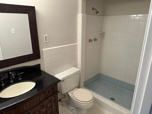 a bathroom with a granite countertop sink toilet mirror and shower