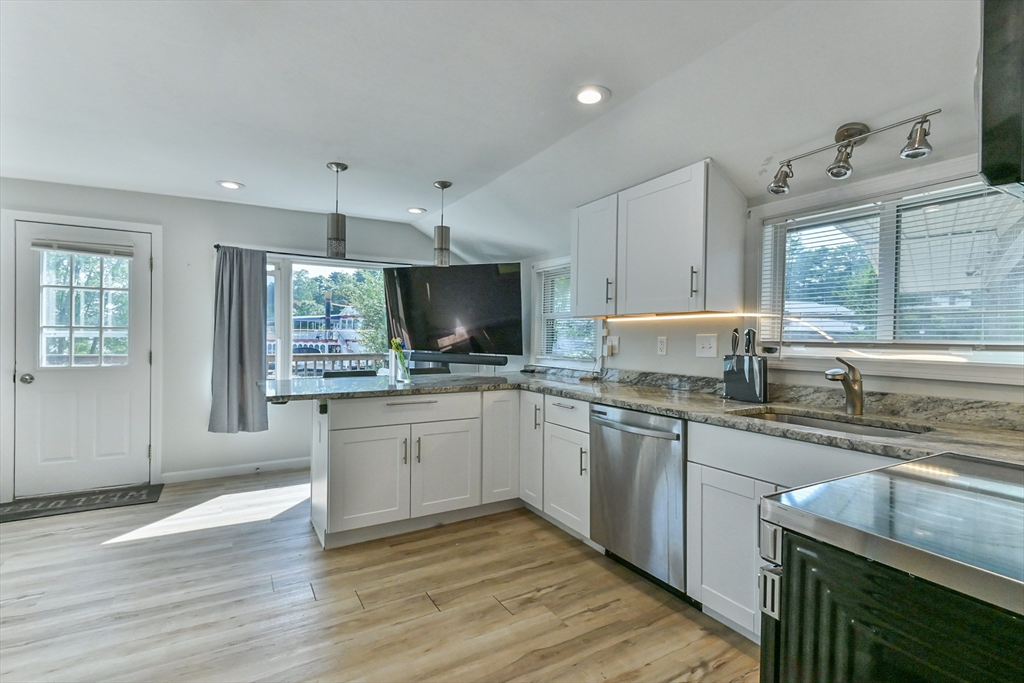 27 Lakeview Road Webster, MA 01570 - Photo 16 of 26 a kitchen with a sink wooden floor and white cabinets