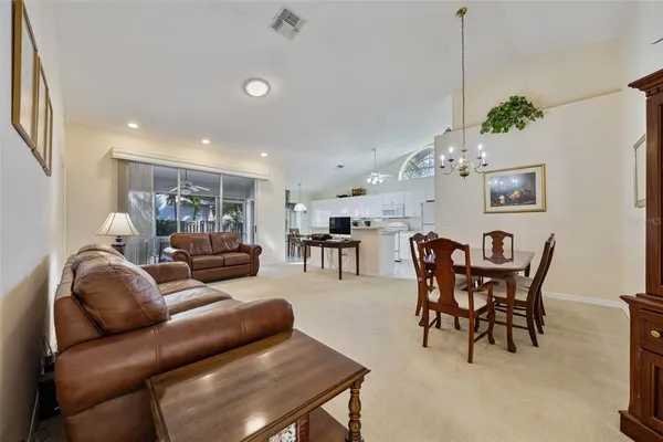 a living room with furniture and a dining table with kitchen view
