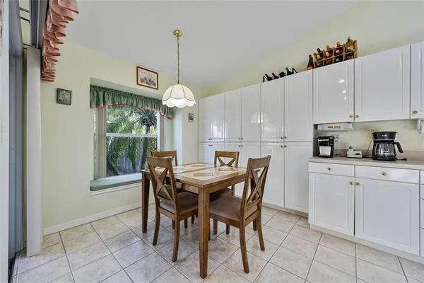 a kitchen with stainless steel appliances granite countertop a sink a microwave oven a refrigerator and white cabinets