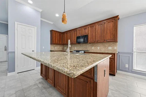 a kitchen with granite countertop a sink and a stove