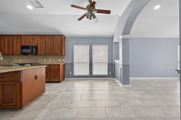 a large kitchen with stainless steel appliances granite countertop a stove a sink and a refrigerator