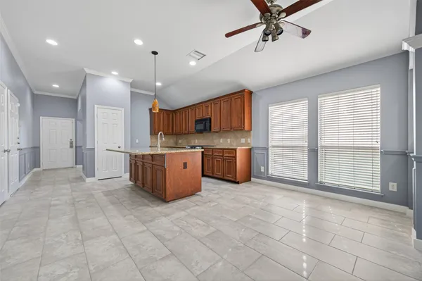 a large kitchen with stainless steel appliances granite countertop a stove top oven a sink dishwasher a dining table and chairs