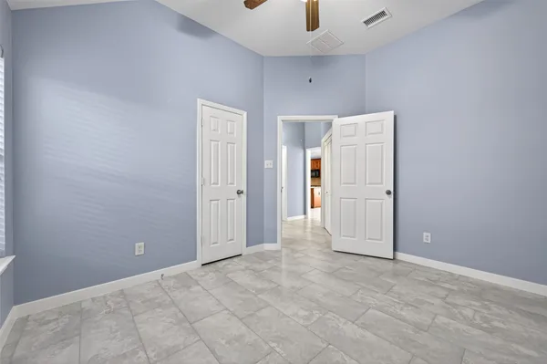 an empty room with closet and windows