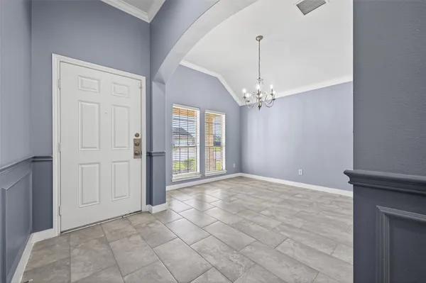 a view of a hallway with windows and chandelier