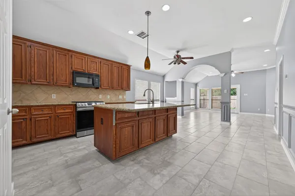 a kitchen with stainless steel appliances granite countertop a sink counter space cabinets and a stove
