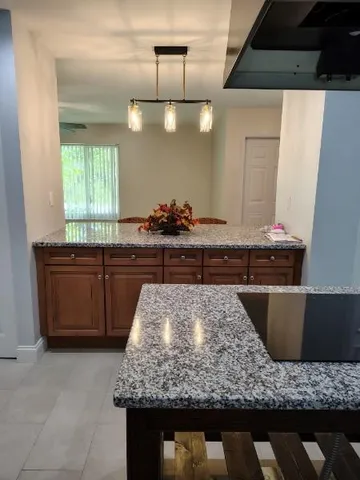 a kitchen with kitchen island granite countertop counter top space a sink and stainless steel appliances