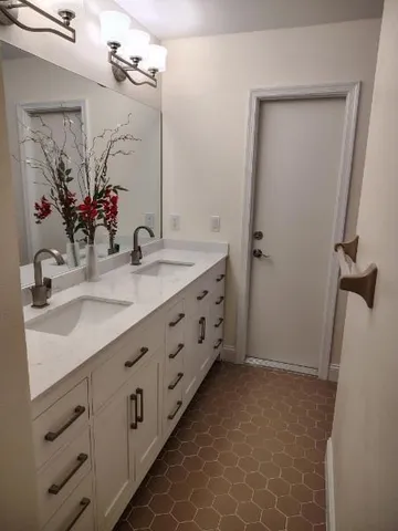 a bathroom with a double vanity sink a mirror and a shower
