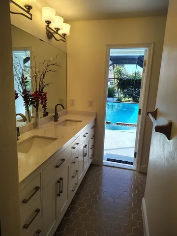 a bathroom with a double vanity sink and a mirror