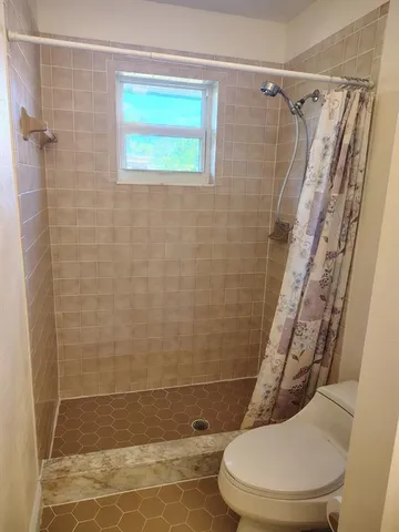 a bathroom with a toilet and a shower