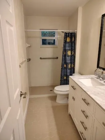 a bathroom with a granite countertop sink toilet and shower