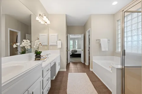 a bathroom with a double vanity sink a mirror a bathtub and shower