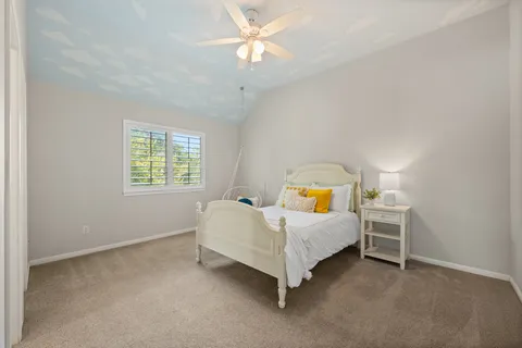 a spacious bedroom with a bed and a chandelier