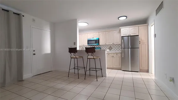 a kitchen with cabinets stainless steel appliances and a counter space