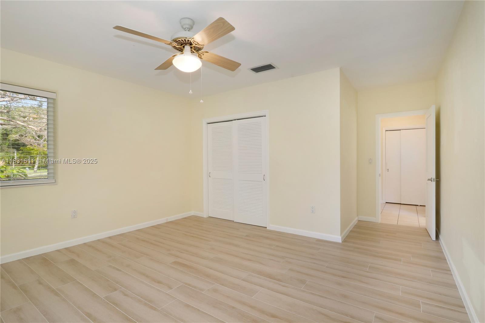 12501 Moss Ranch Road Pinecrest, FL 33156 - Photo 11 of 14 an empty room with wooden floor and fan