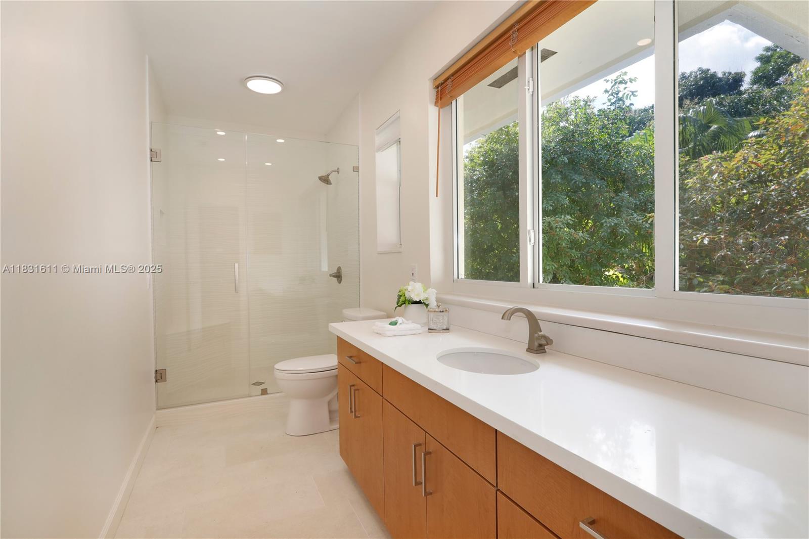 12501 Moss Ranch Road Pinecrest, FL 33156 - Photo 2 of 14 a bathroom with a double vanity sink toilet and a tub