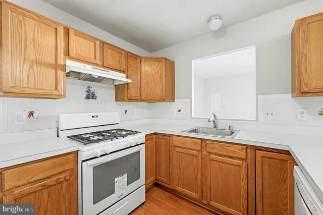 a kitchen with granite countertop a sink stove and cabinets