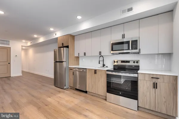 a kitchen with stainless steel appliances a stove microwave and refrigerator