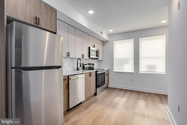 a kitchen with a refrigerator a sink and cabinets
