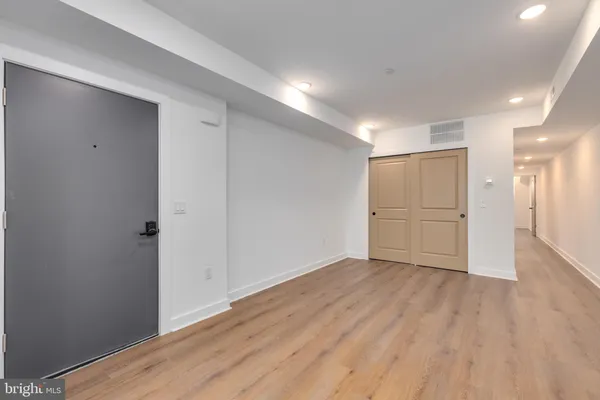 a view of an empty room with wooden floor