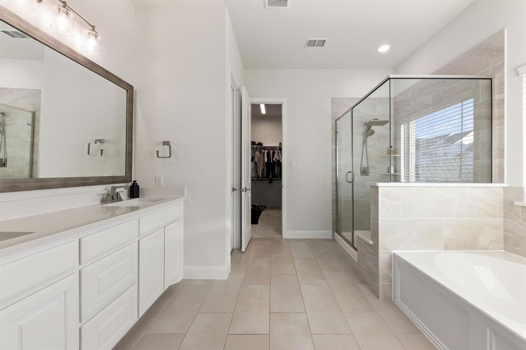 8808 Royal Star Road Rowlett, TX 75089 - Photo 24 of 40 a bathroom with a sink a mirror and a bathtub