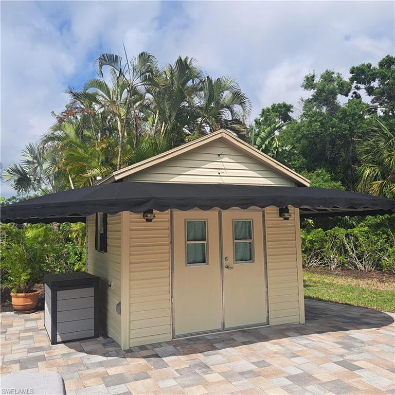 4983 Coach Lane Naples, FL 34114 - Photo 5 of 12 a front view of a house with garden
