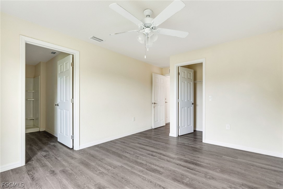 1405 Inwood Road LaBelle, FL 33935 - Photo 11 of 35 an empty room with wooden floor and a ceiling fan