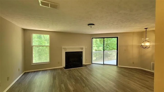 an empty room with windows and fireplace