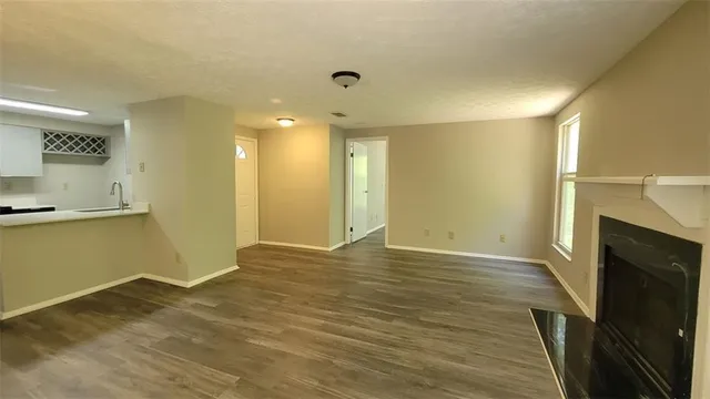 a view of empty room with wooden floor and fireplace